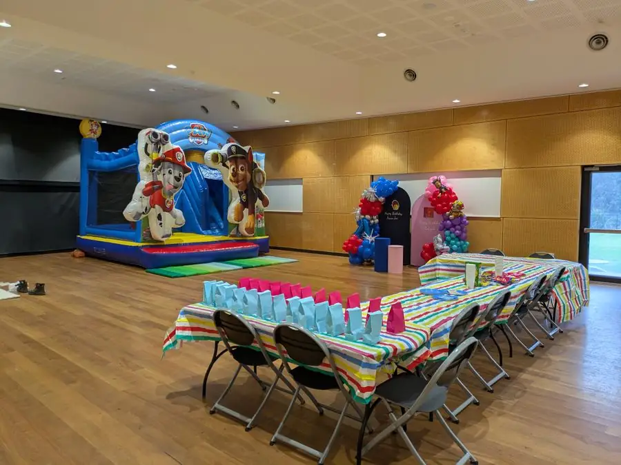 Paw Patrol jumping castle set up indoors, with the party tables ready for guests — Perth, WA